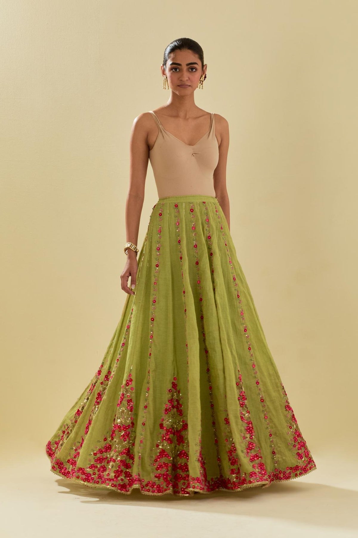 Green tissue chanderi lehenga with all-over delicate hand cut silk flower embroidery, highlighted with gold sequins.