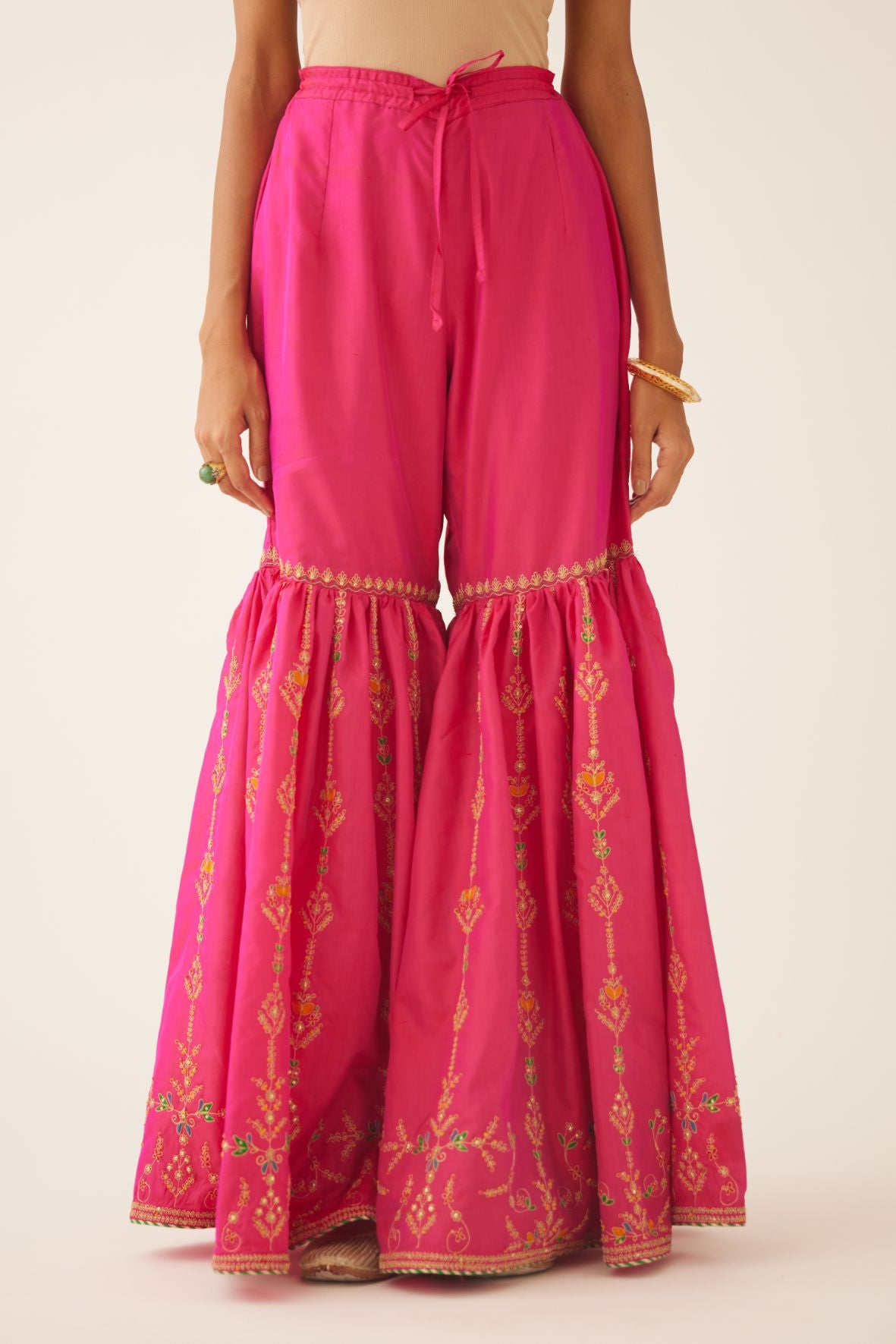 Raspberry silk farshi with delicate dori and silk thread embroidery, highlighted with dori embroidery at knee joint seam.