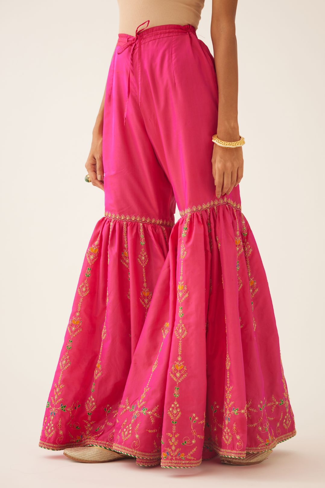 Raspberry silk farshi with delicate dori and silk thread embroidery, highlighted with dori embroidery at knee joint seam.