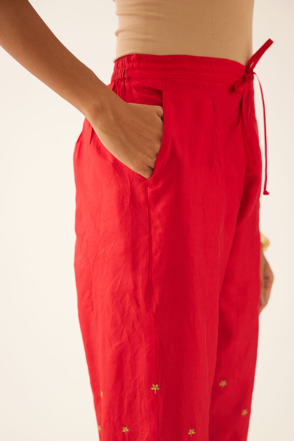 Red silk pants, hem is detailed with zari & gota embroidery