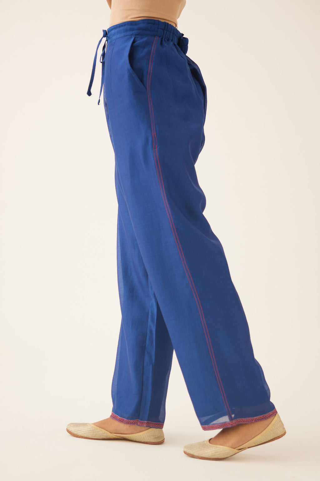 Blue silk chanderi straight pants with quilted embroidery at hem.