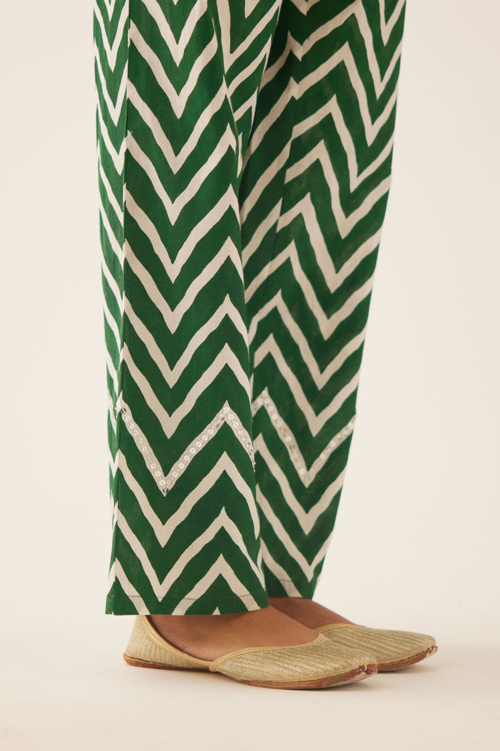 Green & off white cotton hand block printed straight pants detailed with sequin and bead work at hem.