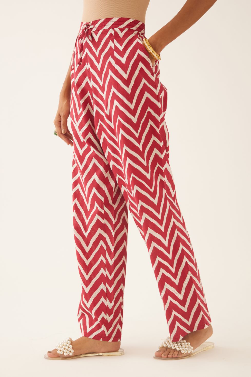 Red & off white cotton hand block printed straight pants detailed with sequin and bead work at hem.
