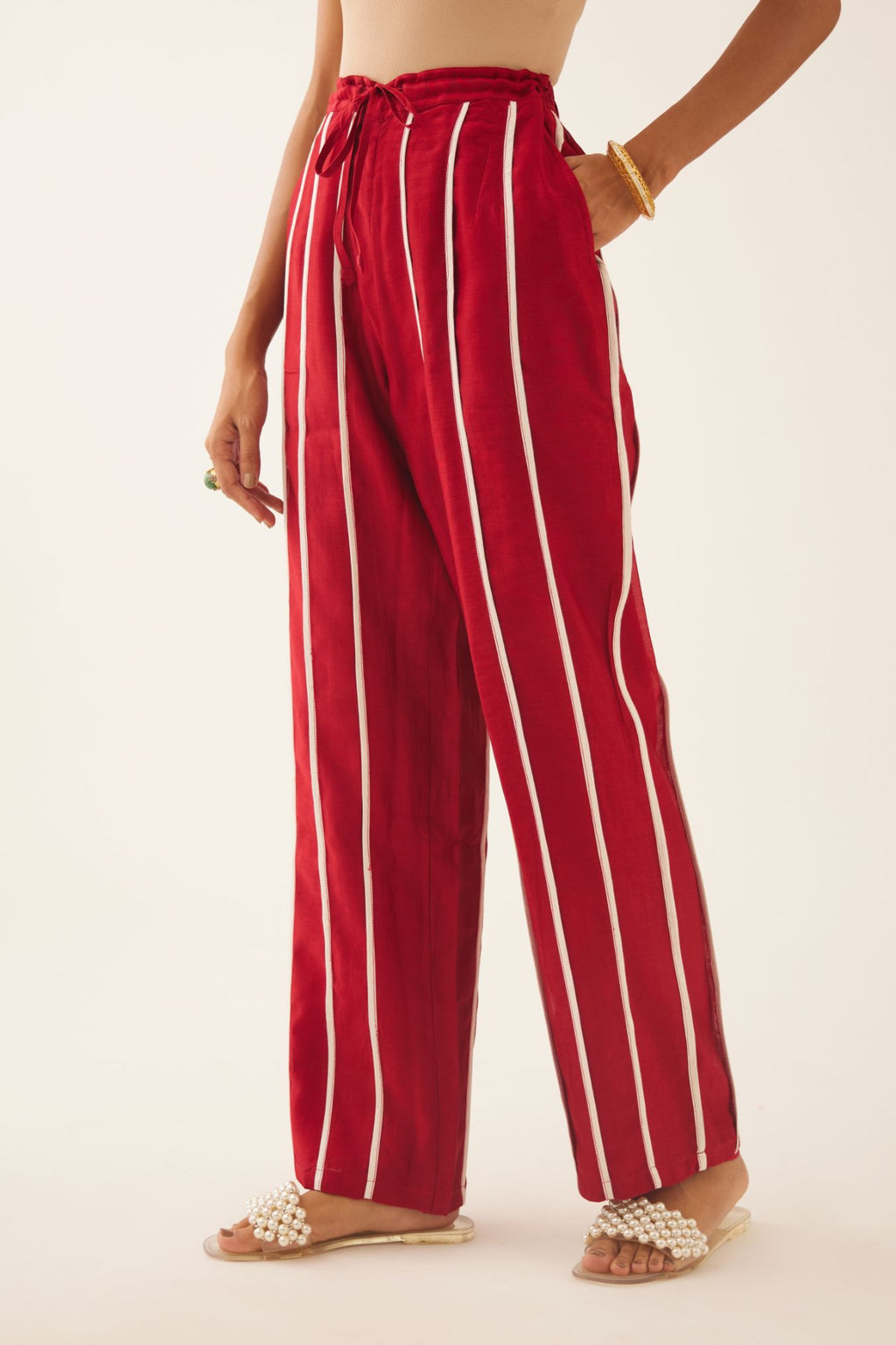 Red silk chanderi straight pants with vertical off white piping detail.