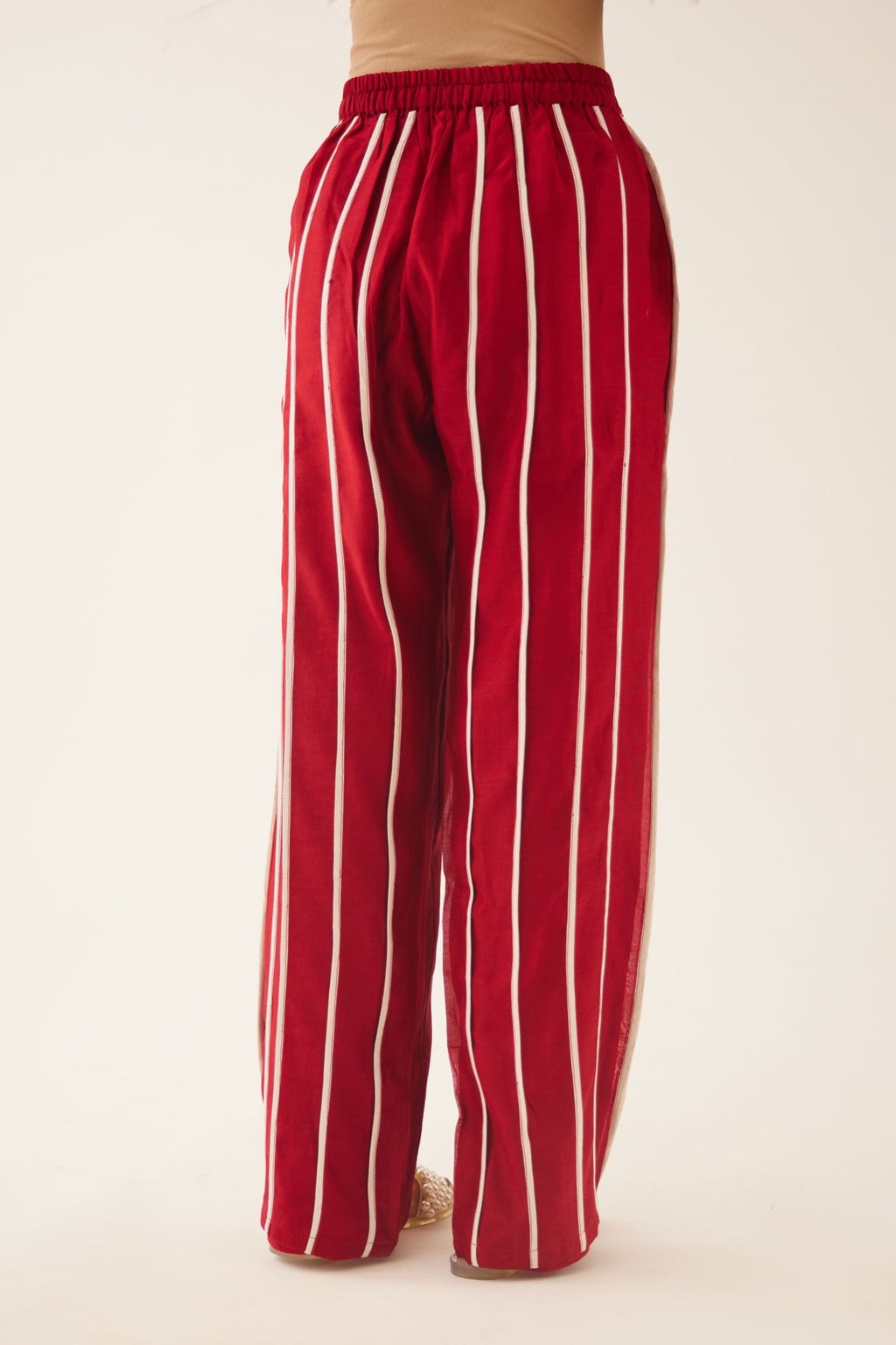 Red silk chanderi straight pants with vertical off white piping detail.