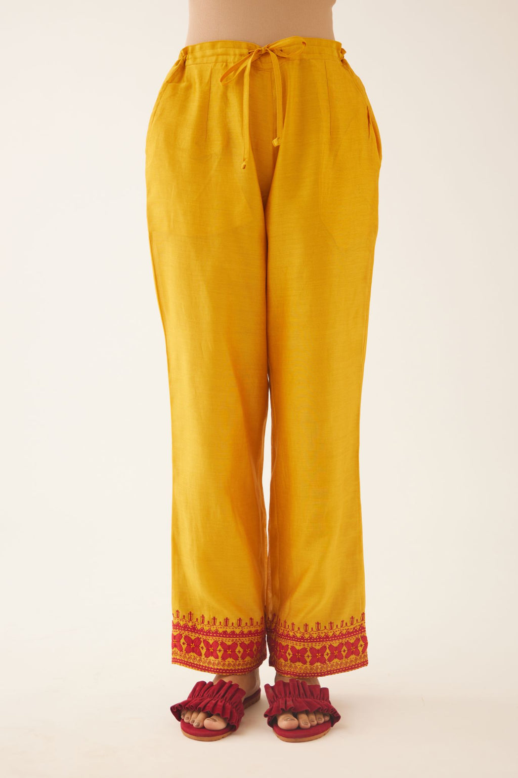 Golden Yellow silk chanderi straight pants detailed with contrast red applique & kantha embroidery at hem.