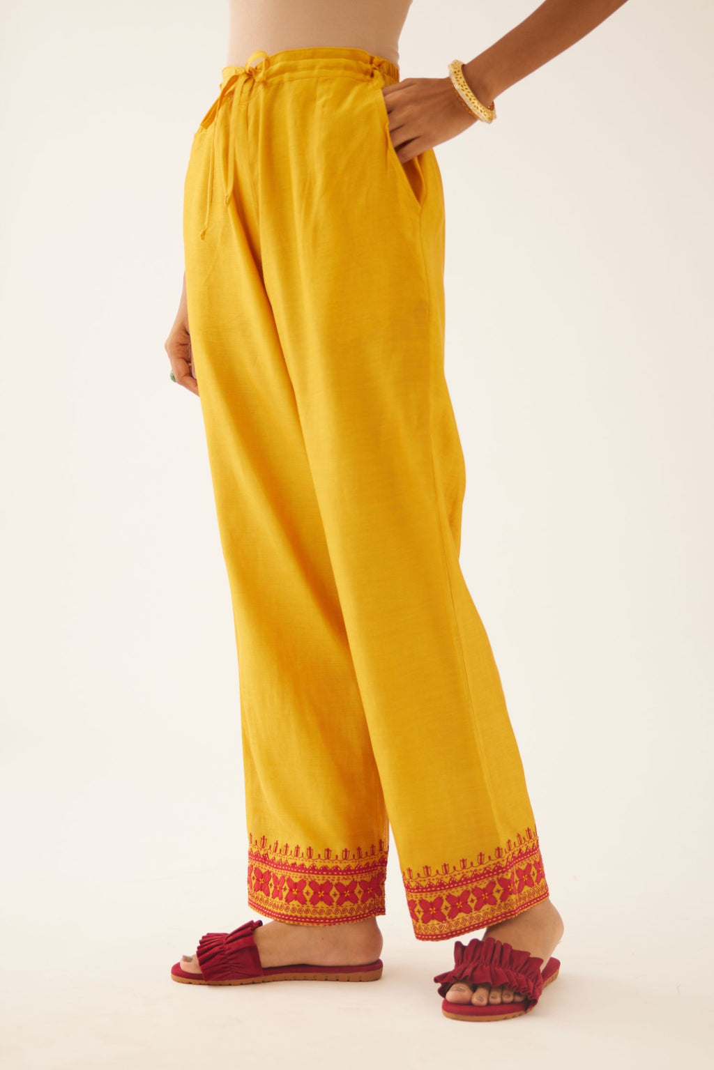 Golden Yellow silk chanderi straight pants detailed with contrast red applique & kantha embroidery at hem.