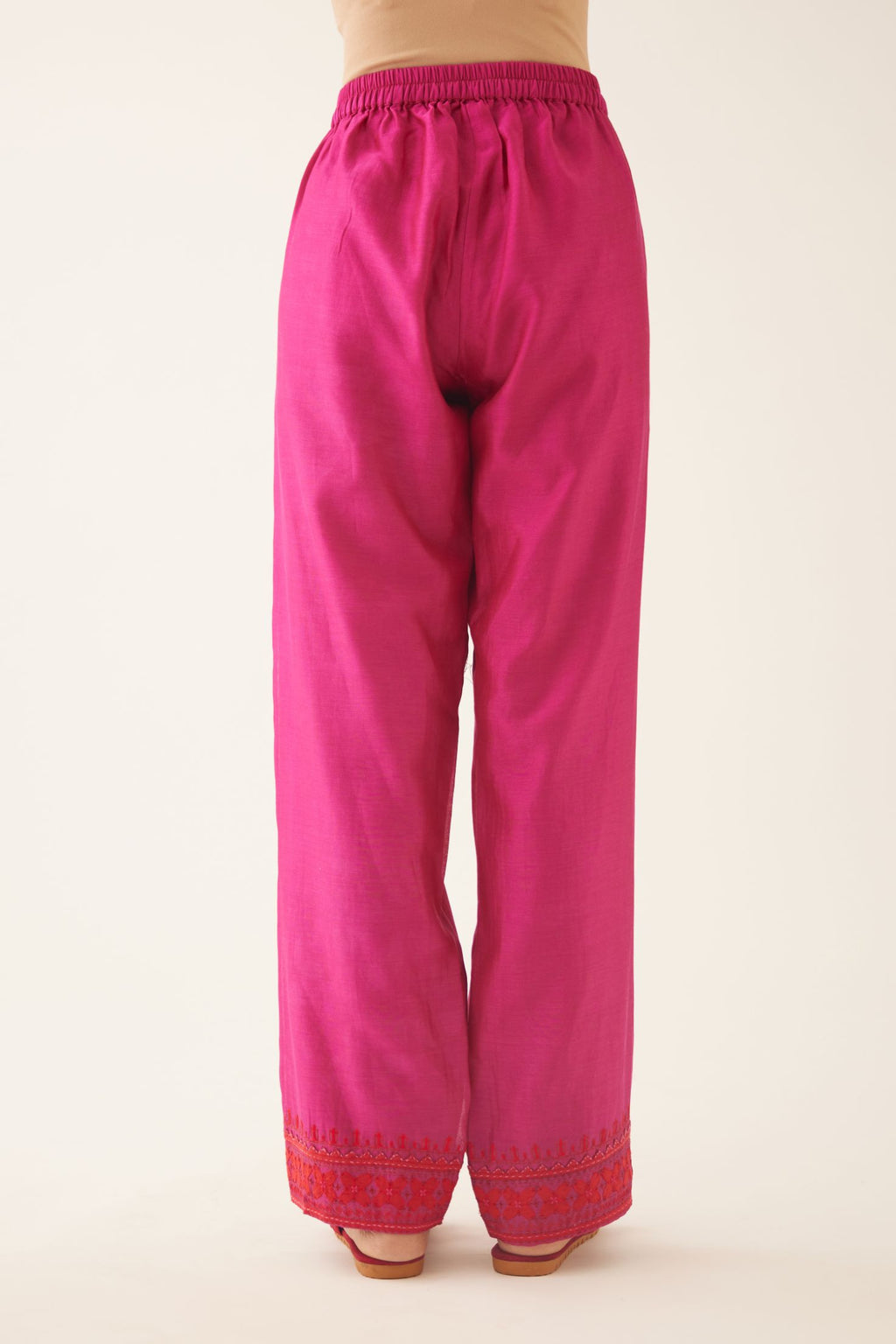 Fuchsia silk chanderi straight pants detailed with contrast red applique & kantha embroidery at hem.