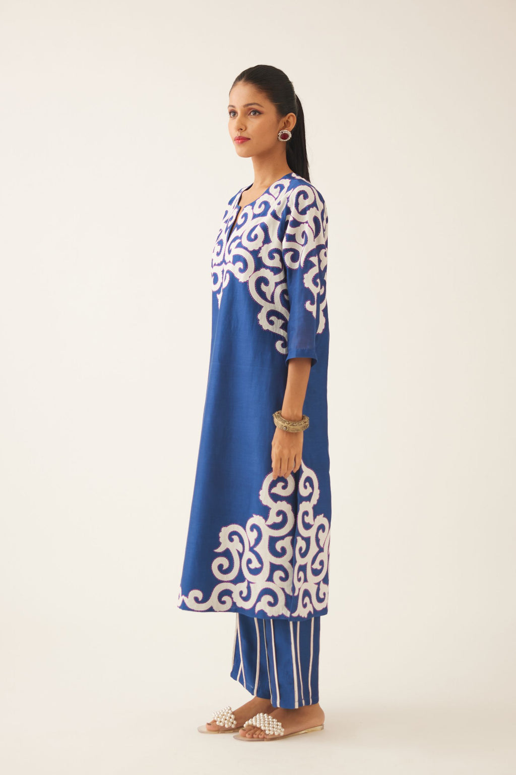 Blue straight kurta with cotton appliqué, highlighted with kantha work, paired with blue silk chanderi straight pants with vertical off white piping detail.
