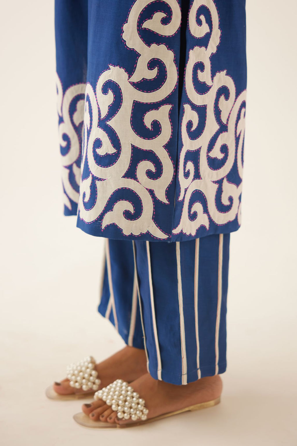 Blue straight kurta with cotton appliqué, highlighted with kantha work, paired with blue silk chanderi straight pants with vertical off white piping detail.