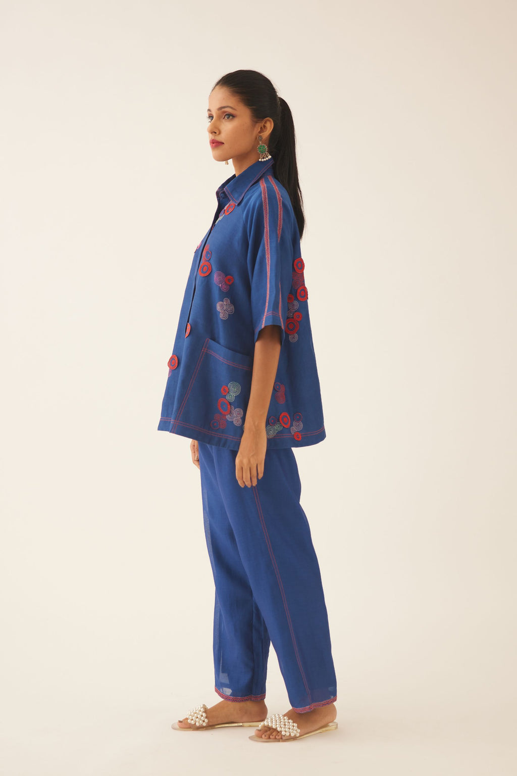 Blue silk chanderi A-line top with shirt collar and multi colored 3D spiral embroidery, paired with blue silk chanderi straight pants with quilted embroidery at hem.