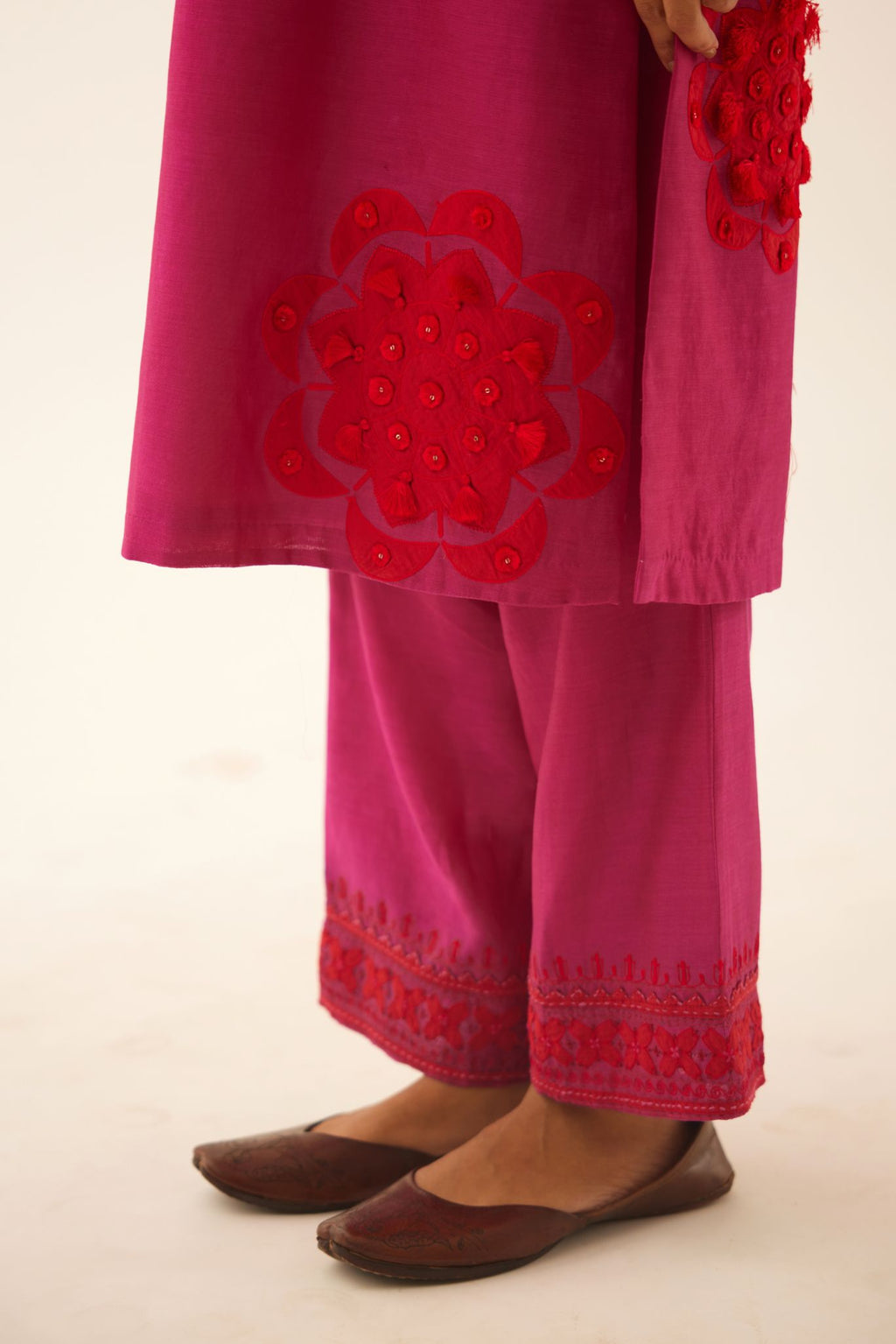 Fushcia silk chanderi straight kurta set with 3/4th sleeve, highlighted with red patch, tassles & sequence work.