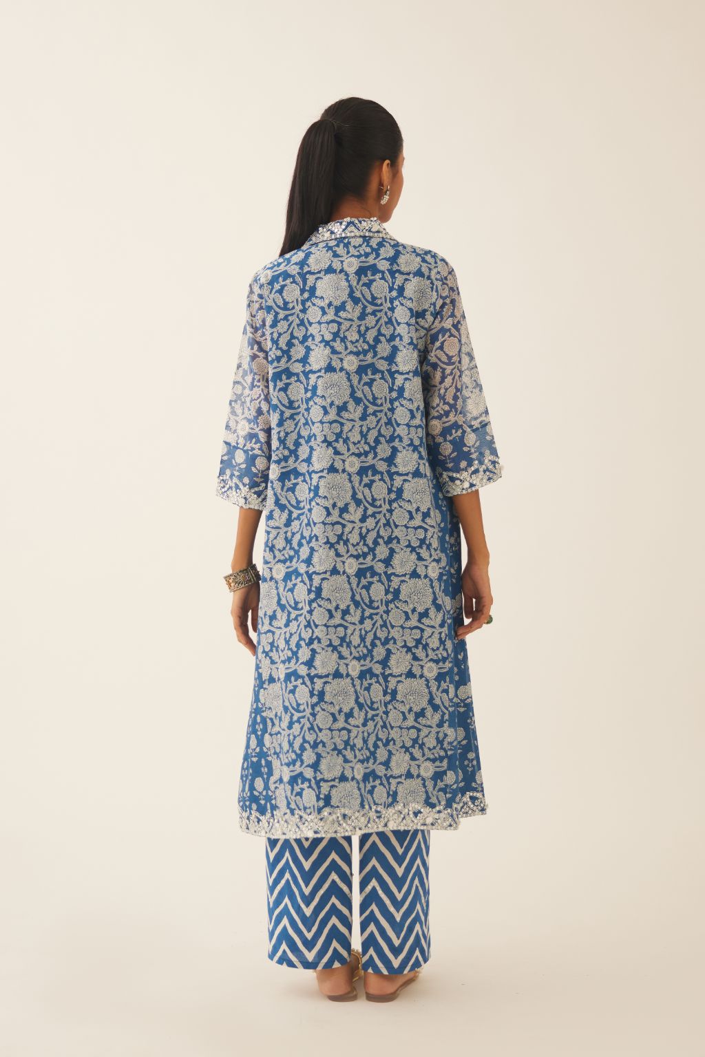Blue hand block printed A-line short kurta with sequins, tassels and bead work, paired with blue & off white cotton hand block printed straight pants detailed with sequin and bead work at hem.