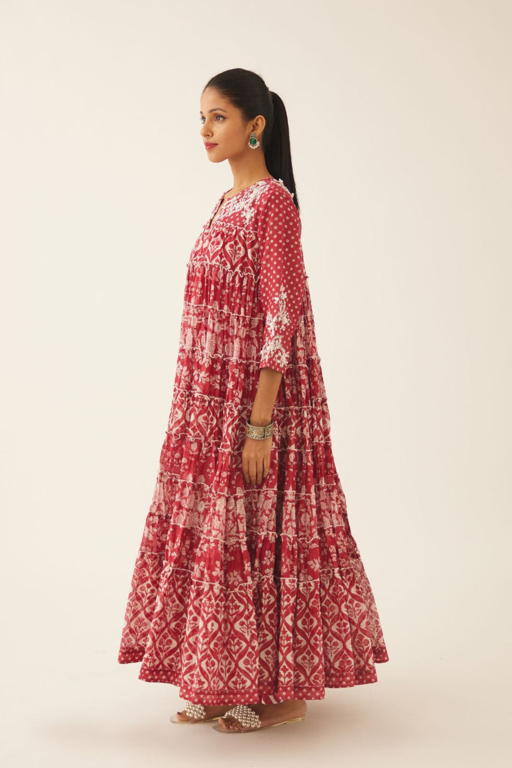 Red hand block printed multi-tiered kurta dress set with 3/4 sleeves, highlighted with sequins, tassels and bead work.