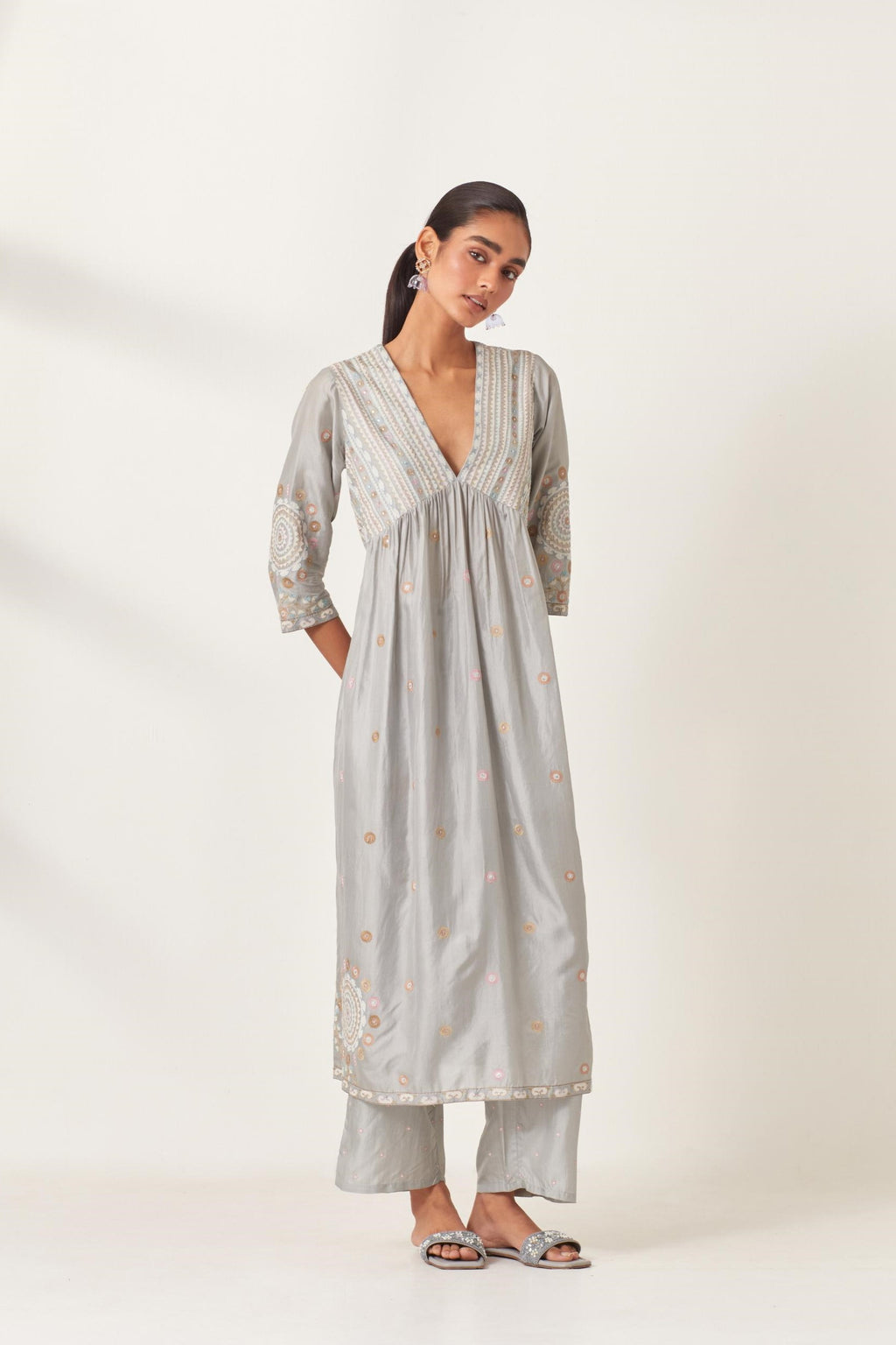 Blue silk kurta dress set with appliqué stripes along with aari threadwork flowers and floral trellises along with a circular appliqued motif and fine gathers at empire line.