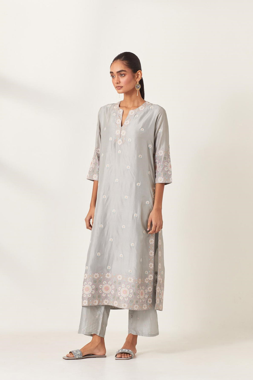 Blue silk kurta set with multi-colored bold appliqué, bootas at borders and aari threadwork, highlighted with sequins.
