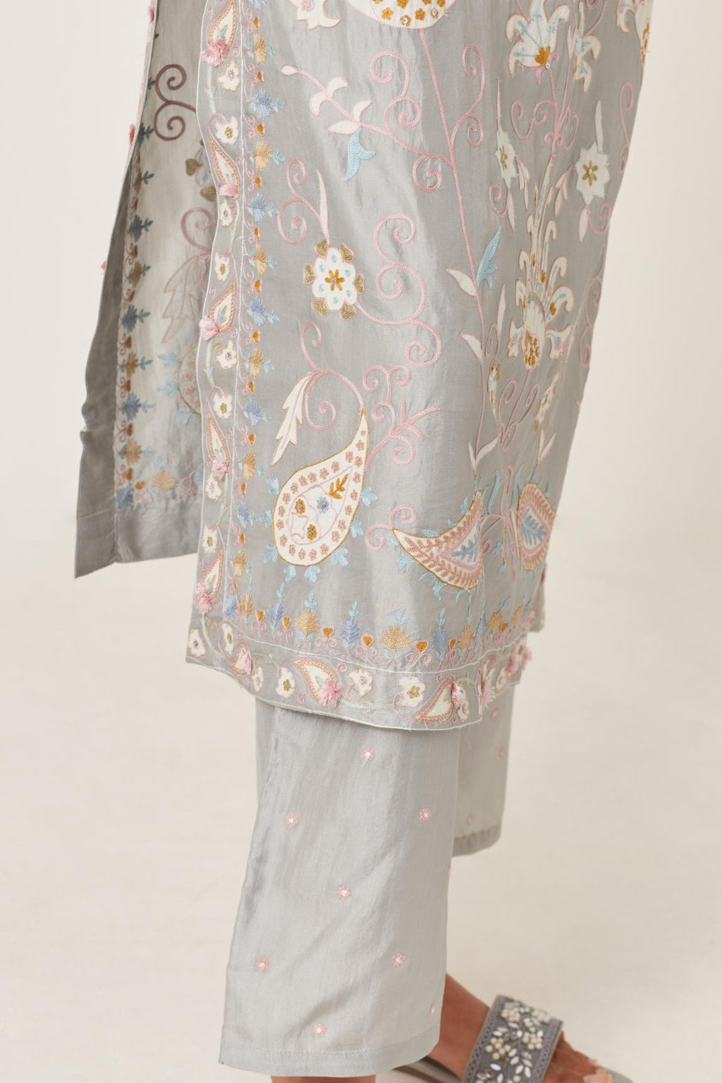 Blue straight kurta set, fully embroidered with bold appliqué flowers, multi-colored aari threadwork and silk tassels.