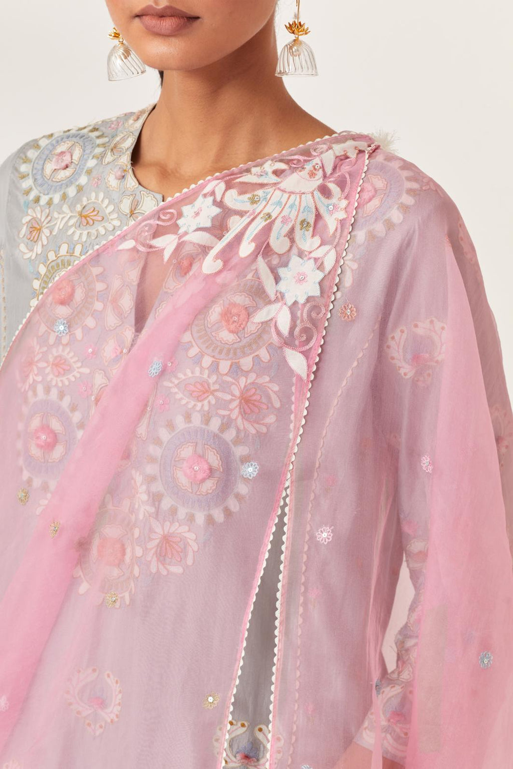 Pink silk organza dupatta with appliqué work and multi colored flower embroidery all-over the dupatta.