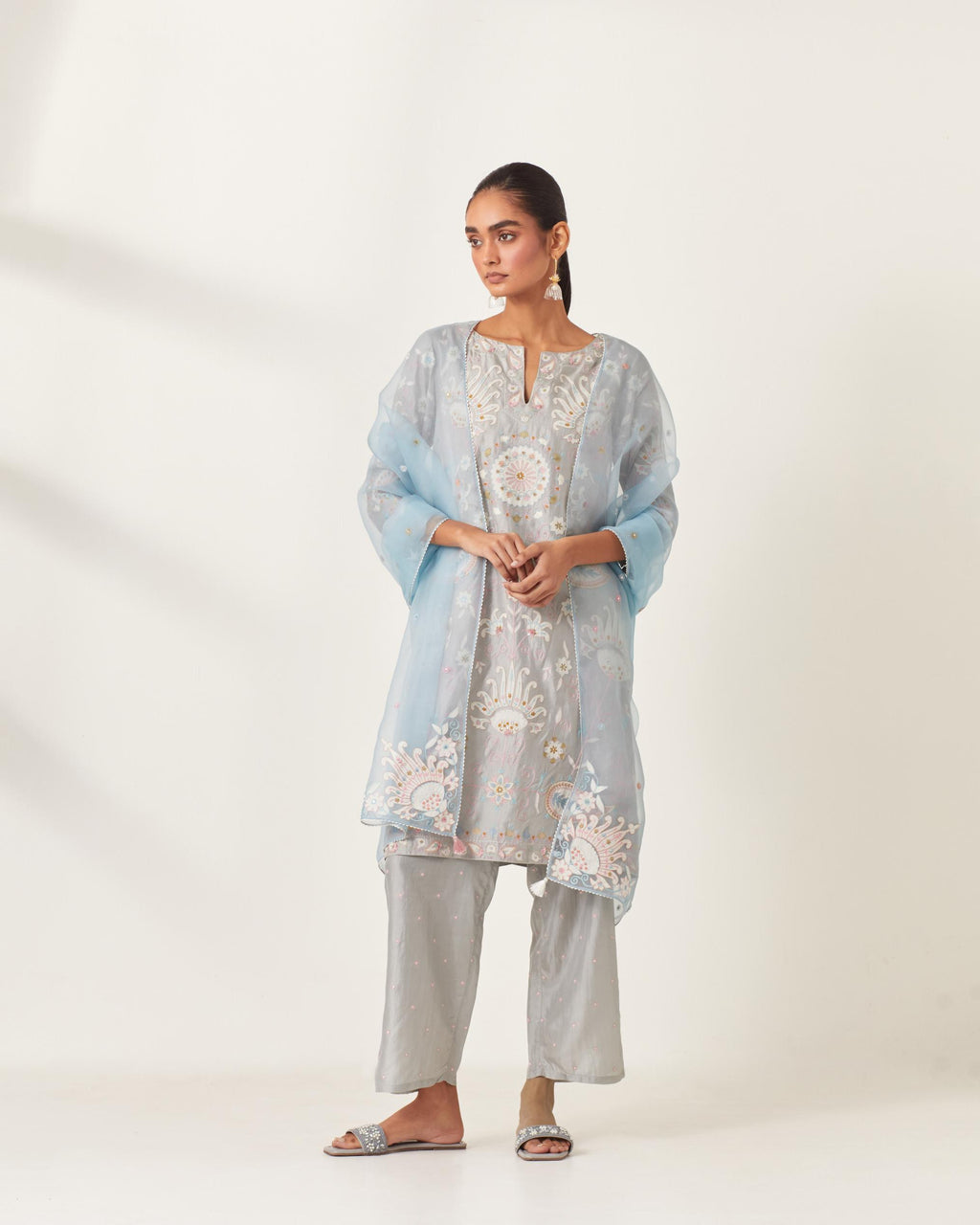 Blue short A-line silk kurta set, fully embroidered with multi colored appliqué with aari thread work and silk tassels.