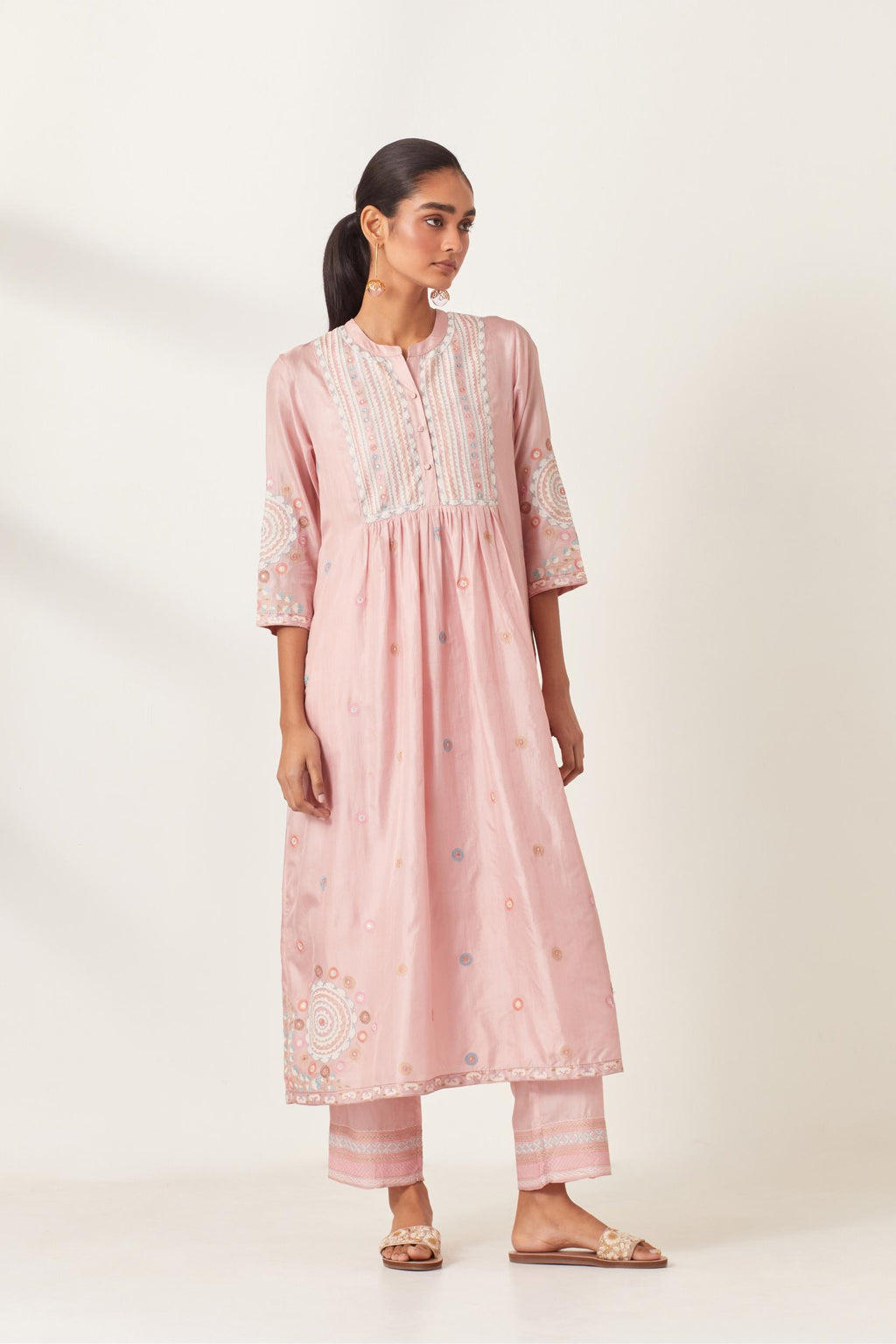 Pink silk gathered kurta-dress set with appliqué stripes along with aari threadwork flowers and floral trellises along with a circular appliqued motif.