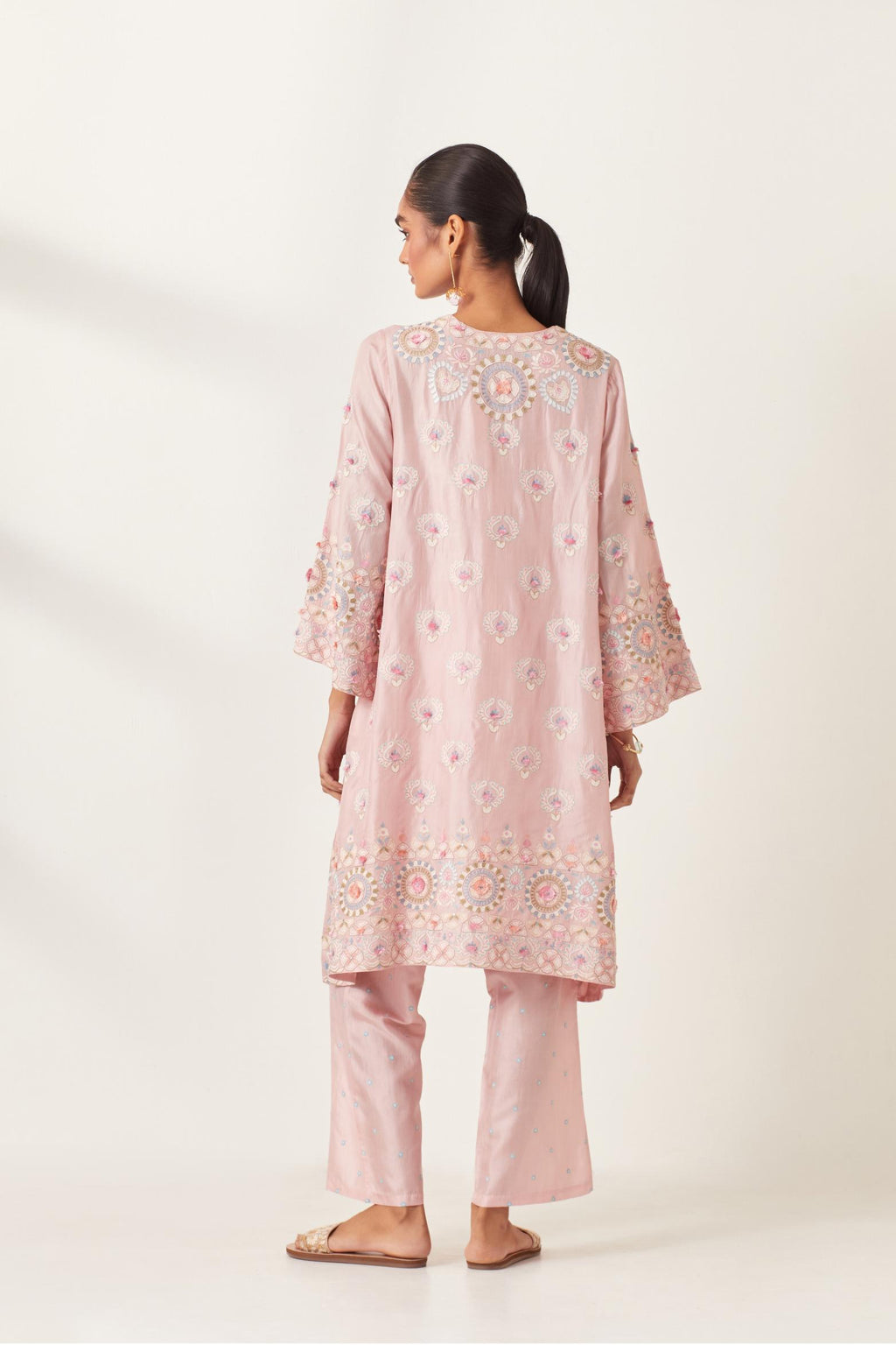 Pink silk straight hem mid-length abha style kurta set with bold appliqué embroidery along with multi-colored aari thread work and tassels.