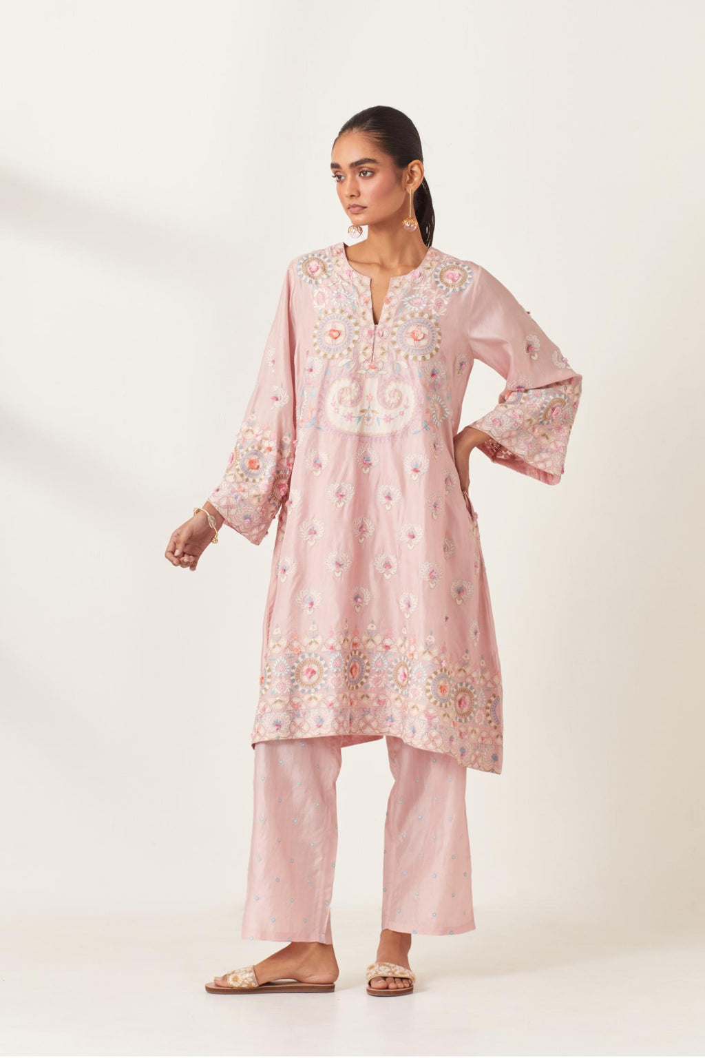 Pink silk straight hem mid-length abha style kurta set with bold appliqué embroidery along with multi-colored aari thread work and tassels.