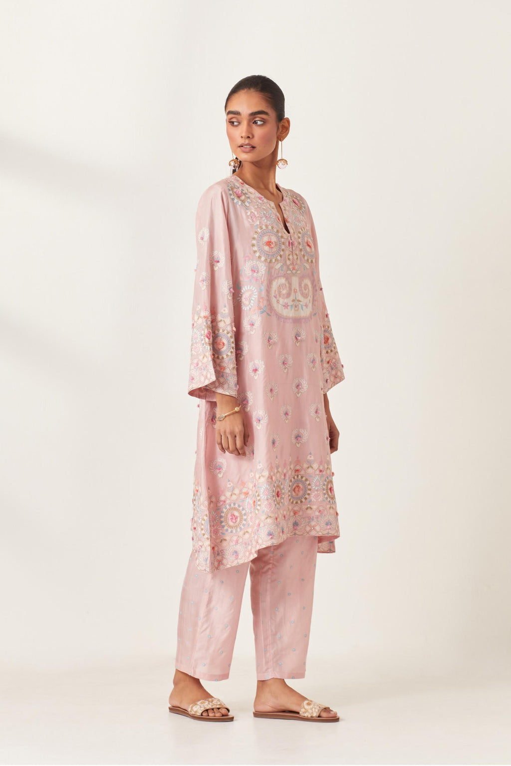 Pink silk straight hem mid-length abha style kurta set with bold appliqué embroidery along with multi-colored aari thread work and tassels.