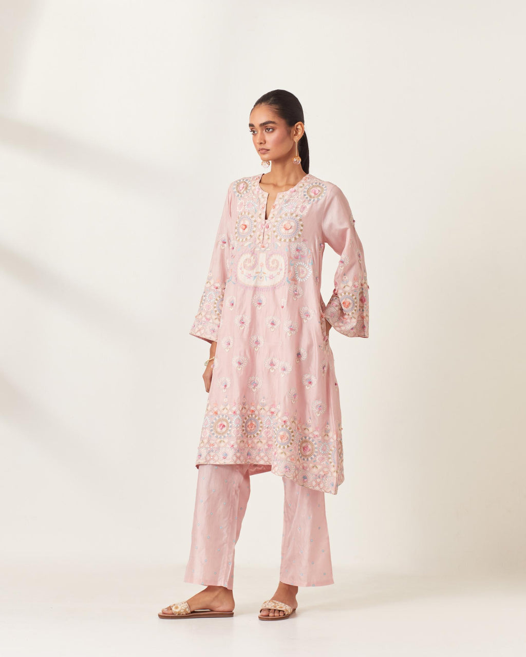 Pink silk straight hem mid-length abha style kurta set with bold appliqué embroidery along with multi-colored aari thread work and tassels.