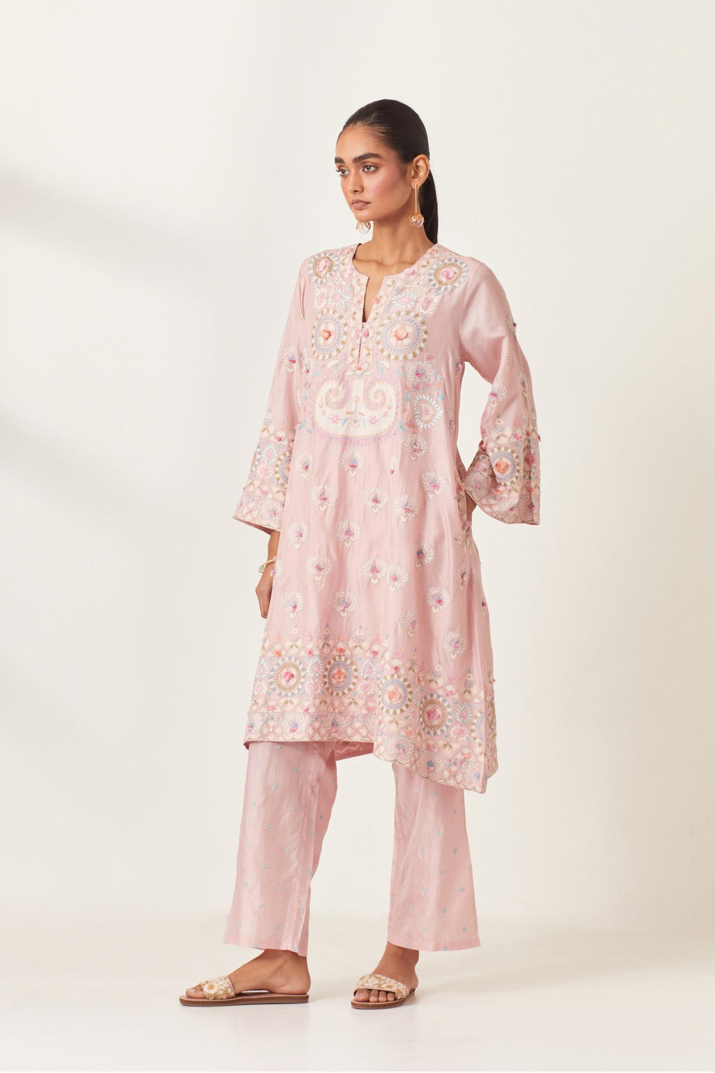 Pink silk straight hem mid-length abha style kurta set with bold appliqué embroidery along with multi-colored aari thread work and tassels.