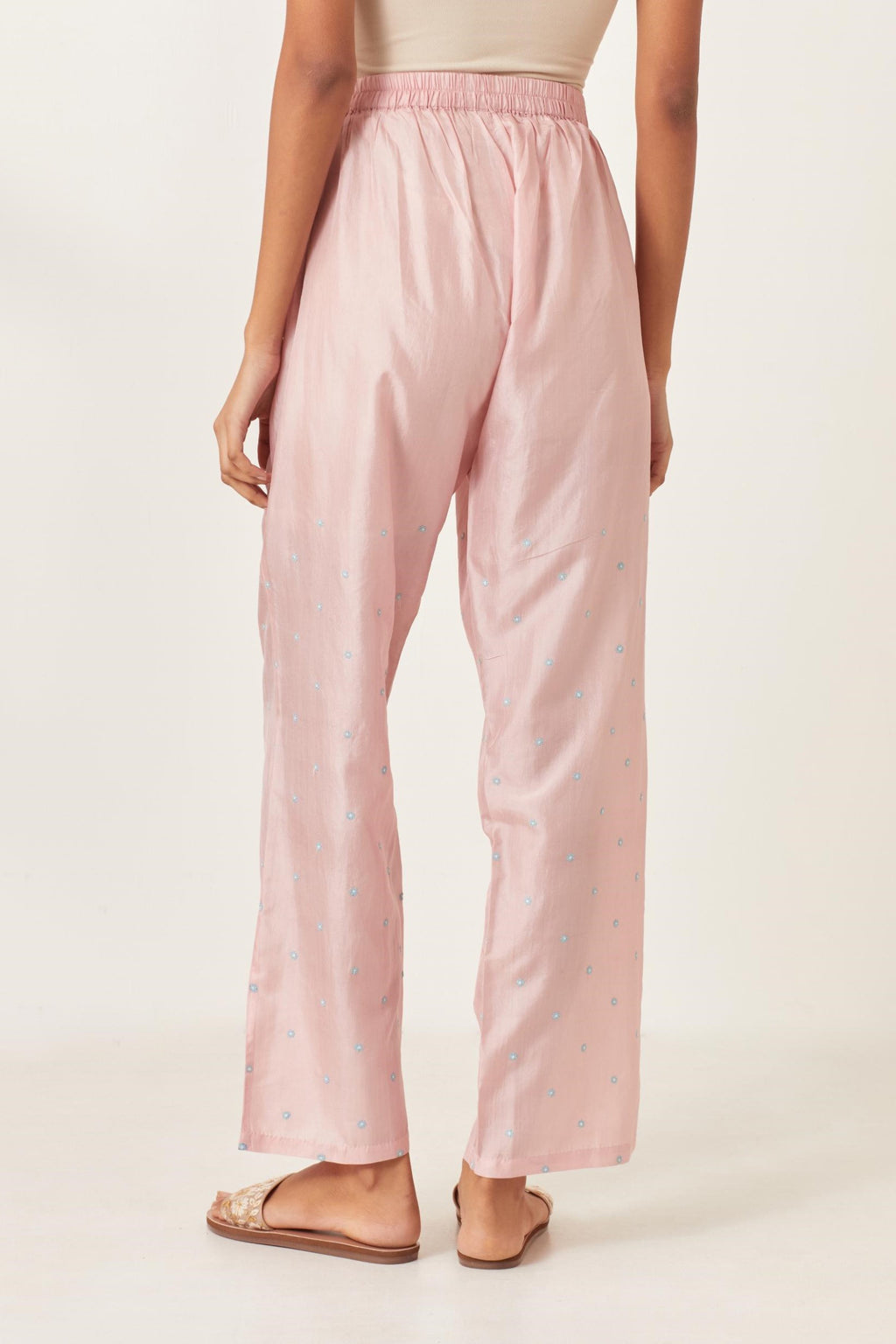 Pink silk straight pants detailed with small flower embroidery at bottom.