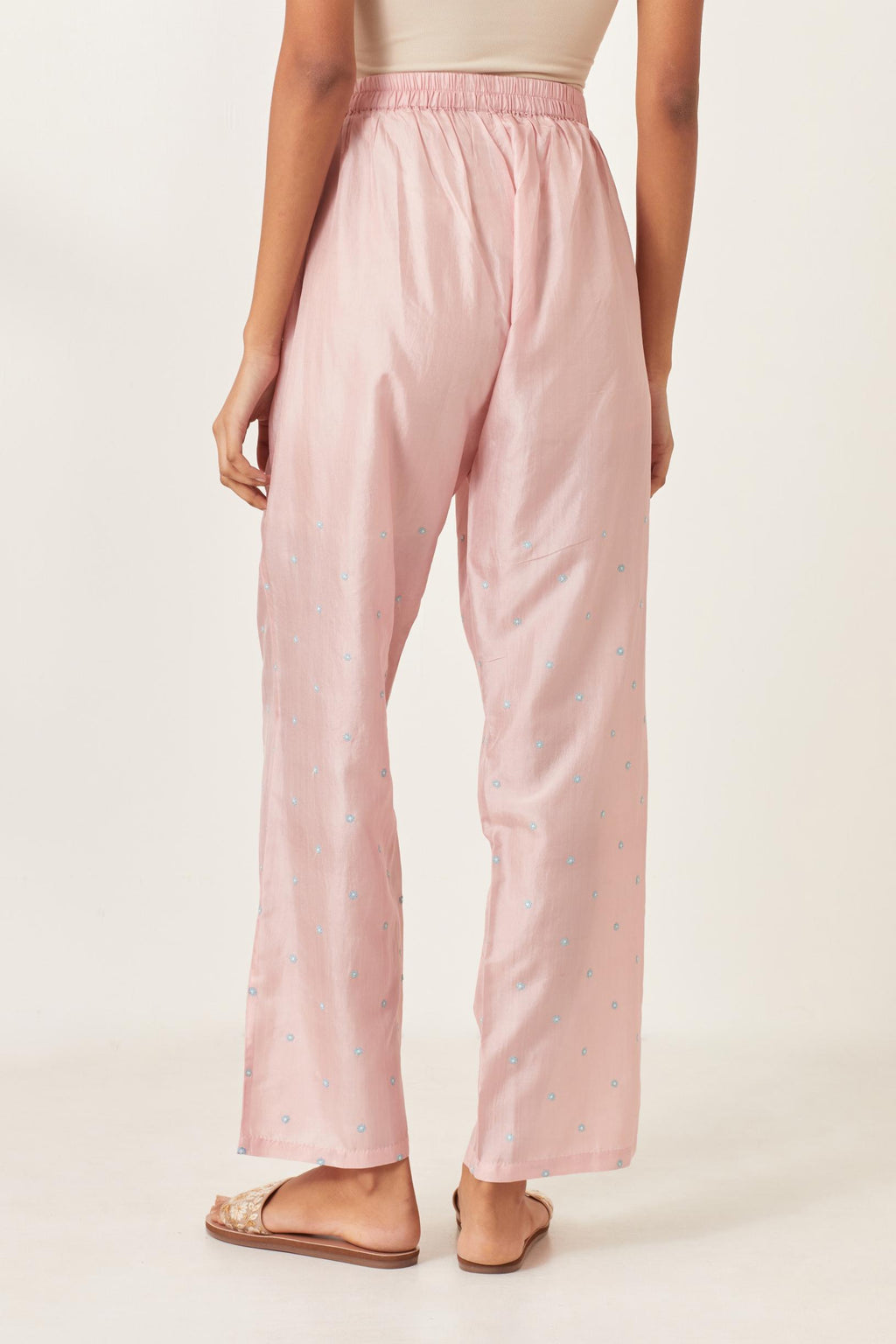 Pink silk straight pants detailed with small flower embroidery at bottom.