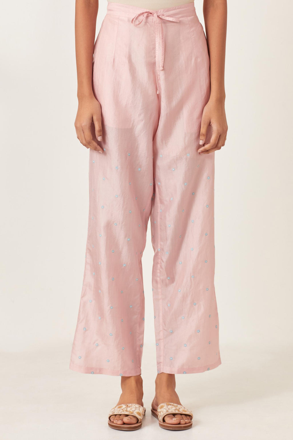 Pink silk straight pants detailed with small flower embroidery at bottom.