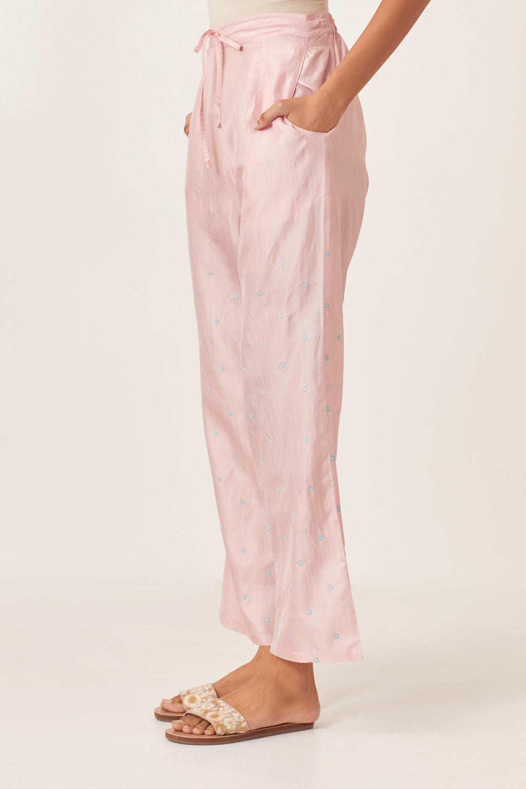 Pink silk straight pants detailed with small flower embroidery at bottom.