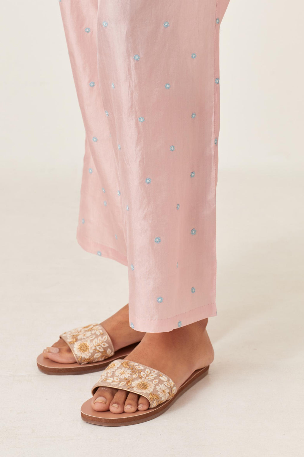 Pink silk straight pants detailed with small flower embroidery at bottom.