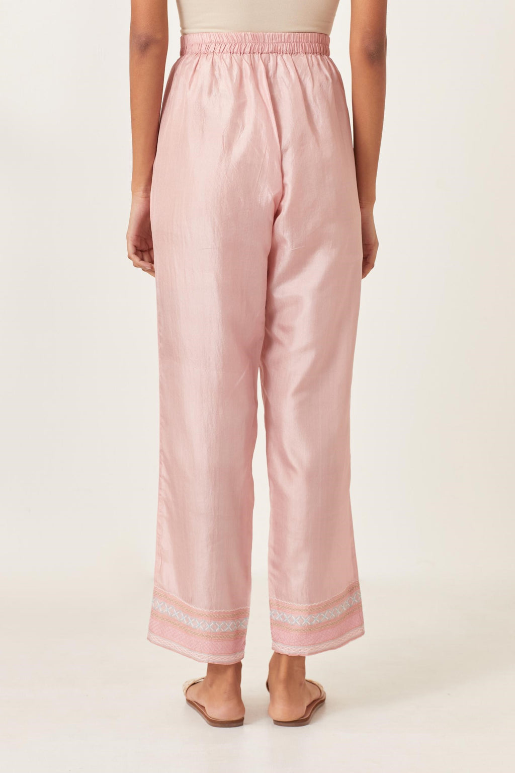 Pink silk straight pants detailed with quilted multi colored embroidery at bottom.