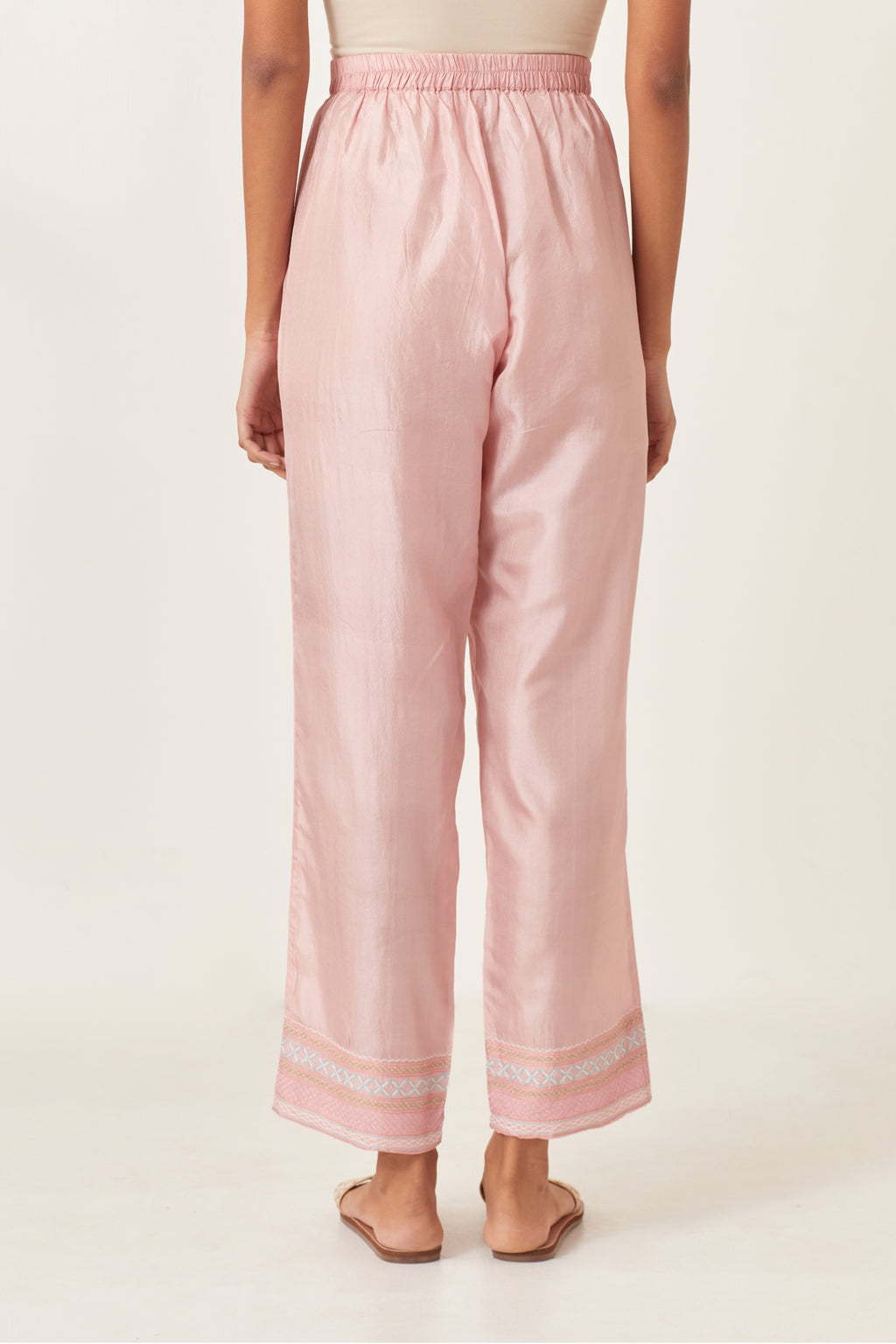 Pink silk straight pants detailed with quilted multi colored embroidery at bottom.