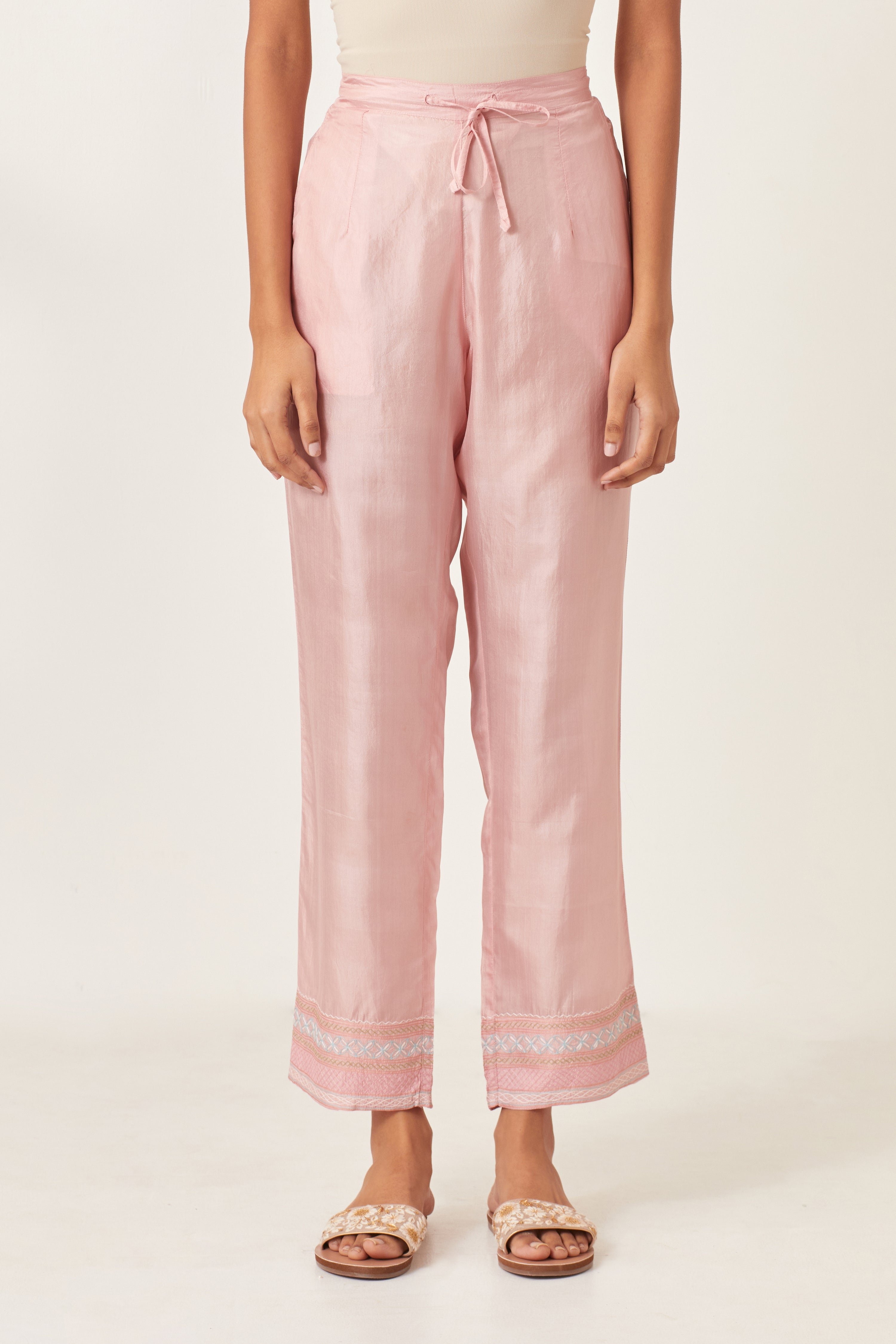 Pink silk straight pants detailed with quilted multi colored embroidery at bottom.
