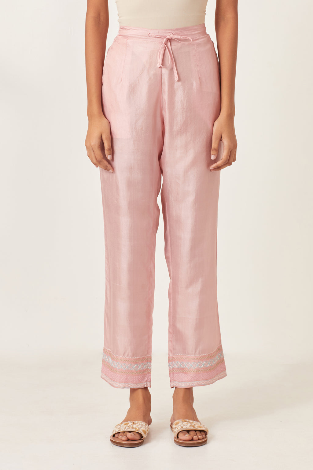 Pink silk straight pants detailed with quilted multi colored embroidery at bottom.