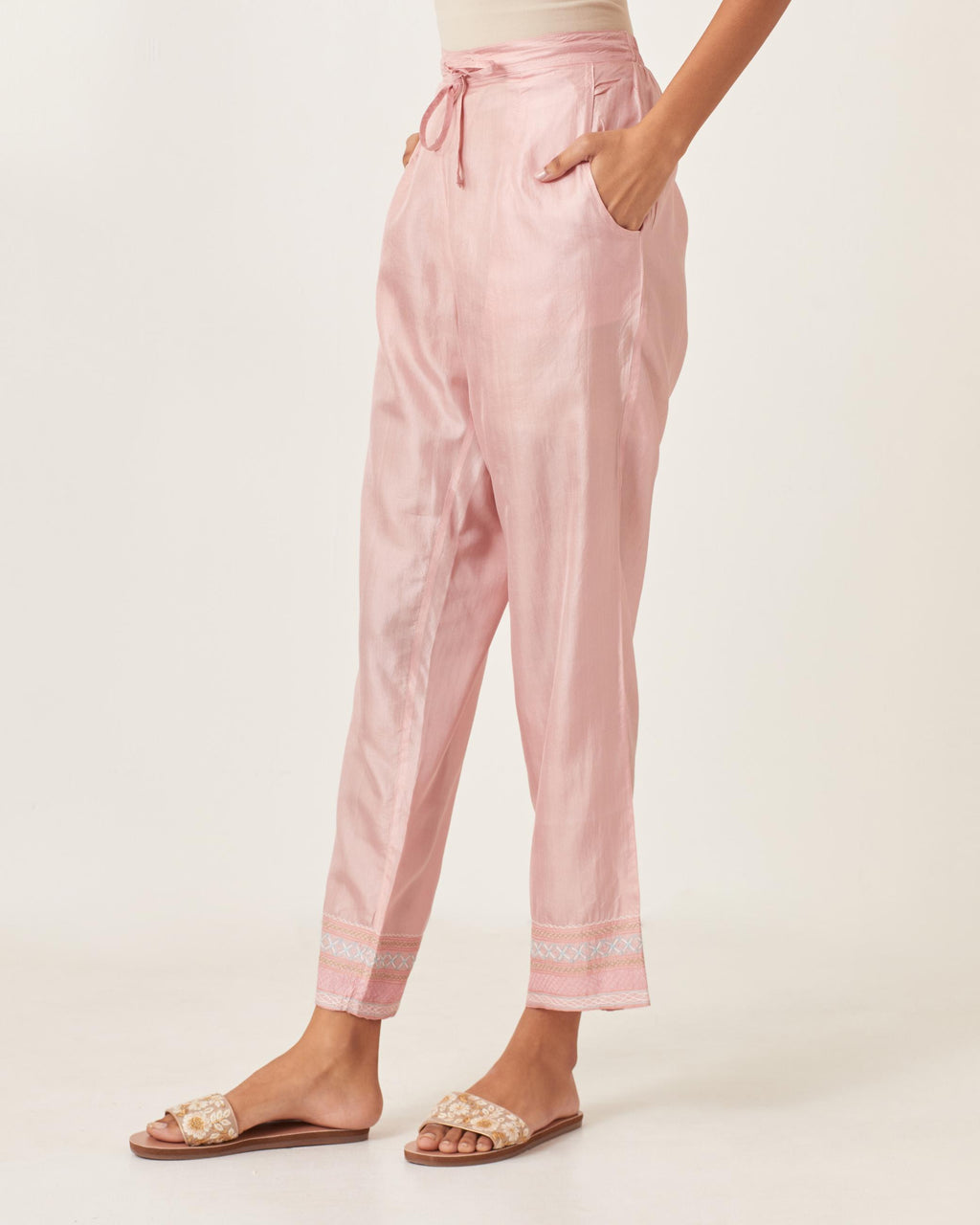 Pink silk straight pants detailed with quilted multi colored embroidery at bottom.