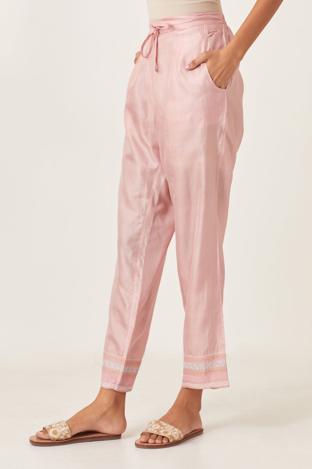 Pink silk straight pants detailed with quilted multi colored embroidery at bottom.