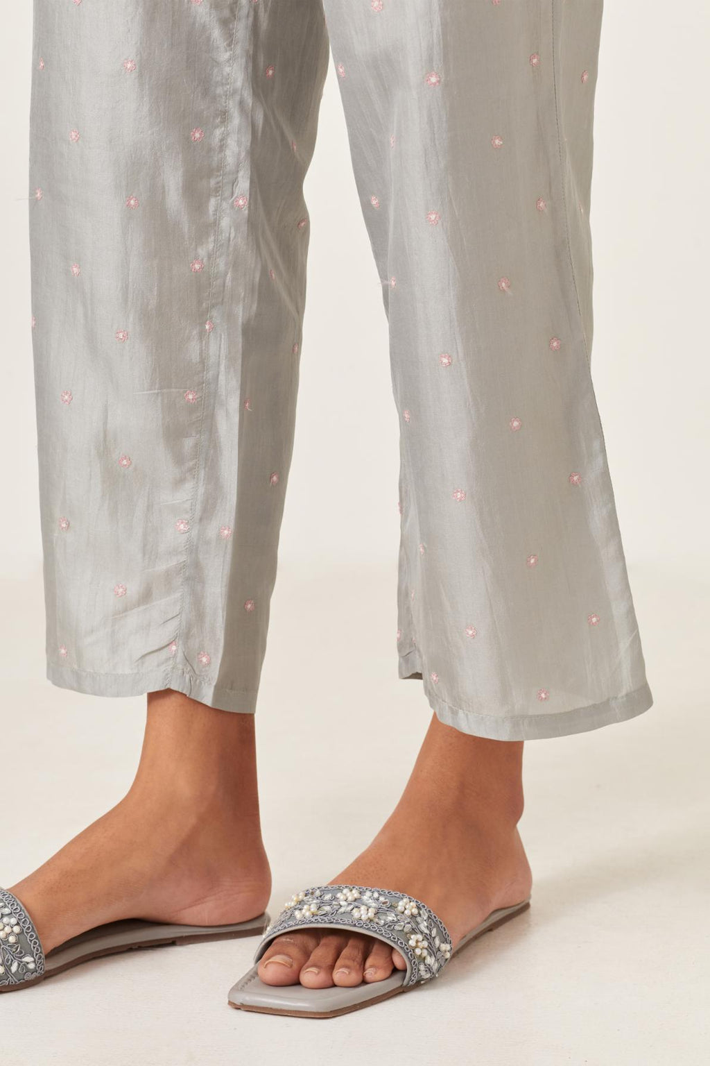 Blue silk straight pants detailed with small flower embroidery at bottom.