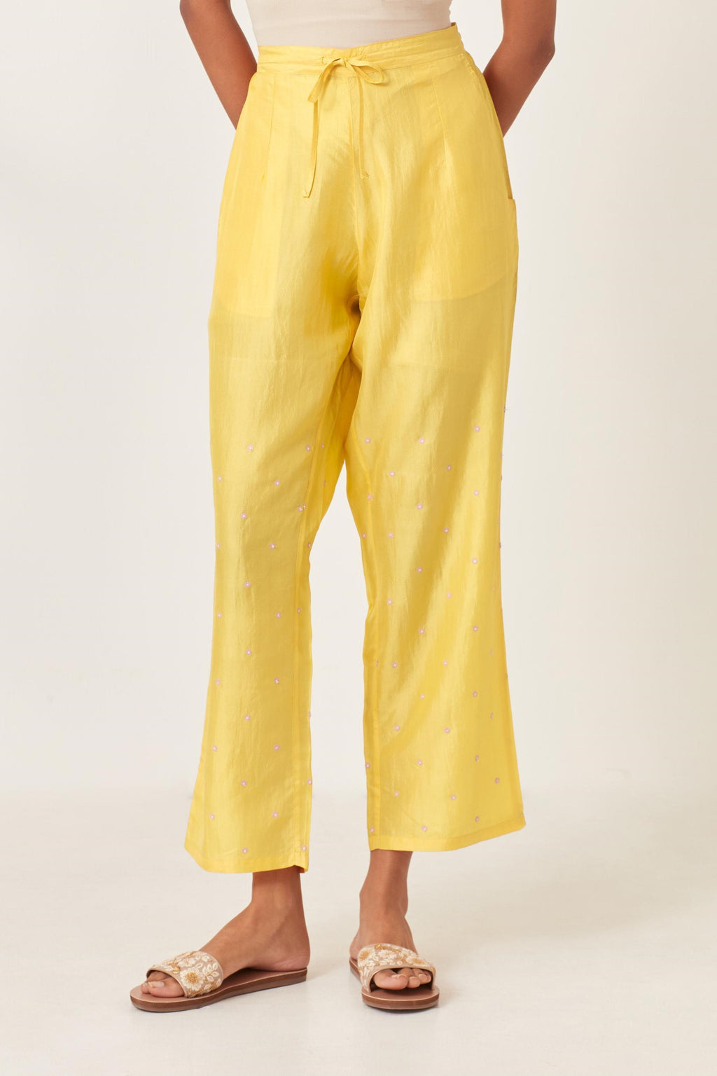 Yellow silk straight pants detailed with small flower embroidery at bottom.