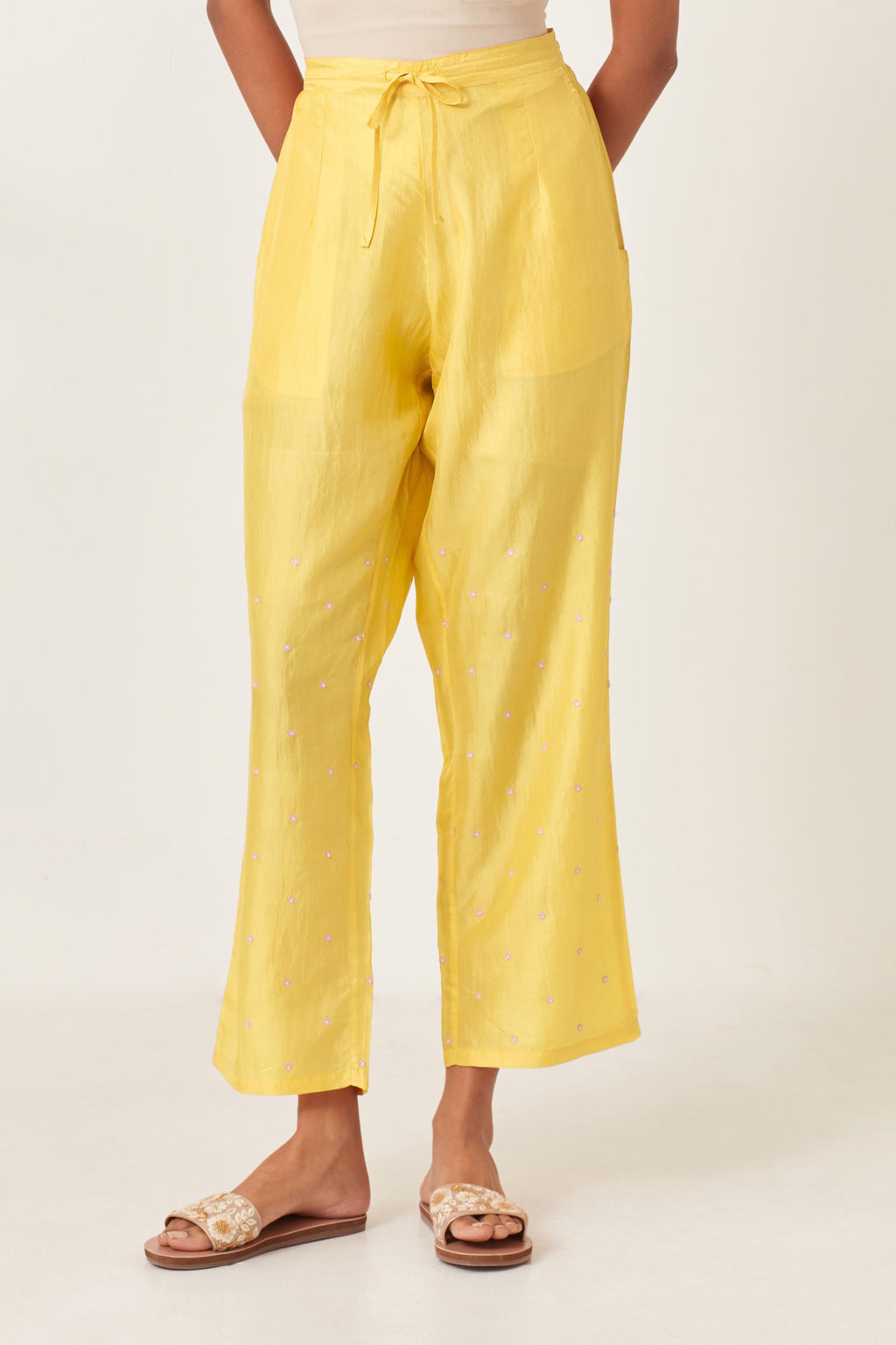 Yellow silk straight pants detailed with small flower embroidery at bottom.