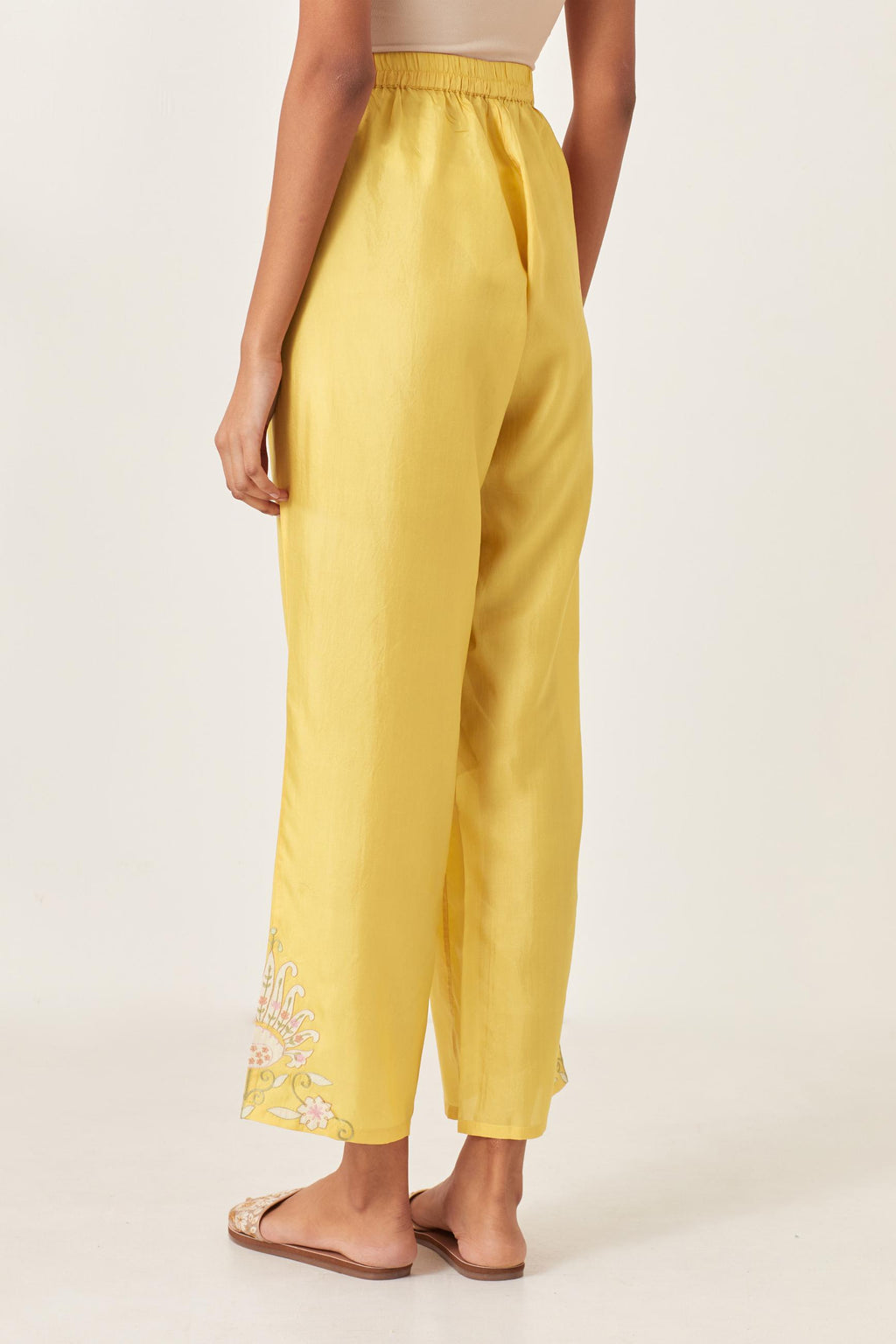 Yellow silk straight pants with multi colored appliqué at hem.