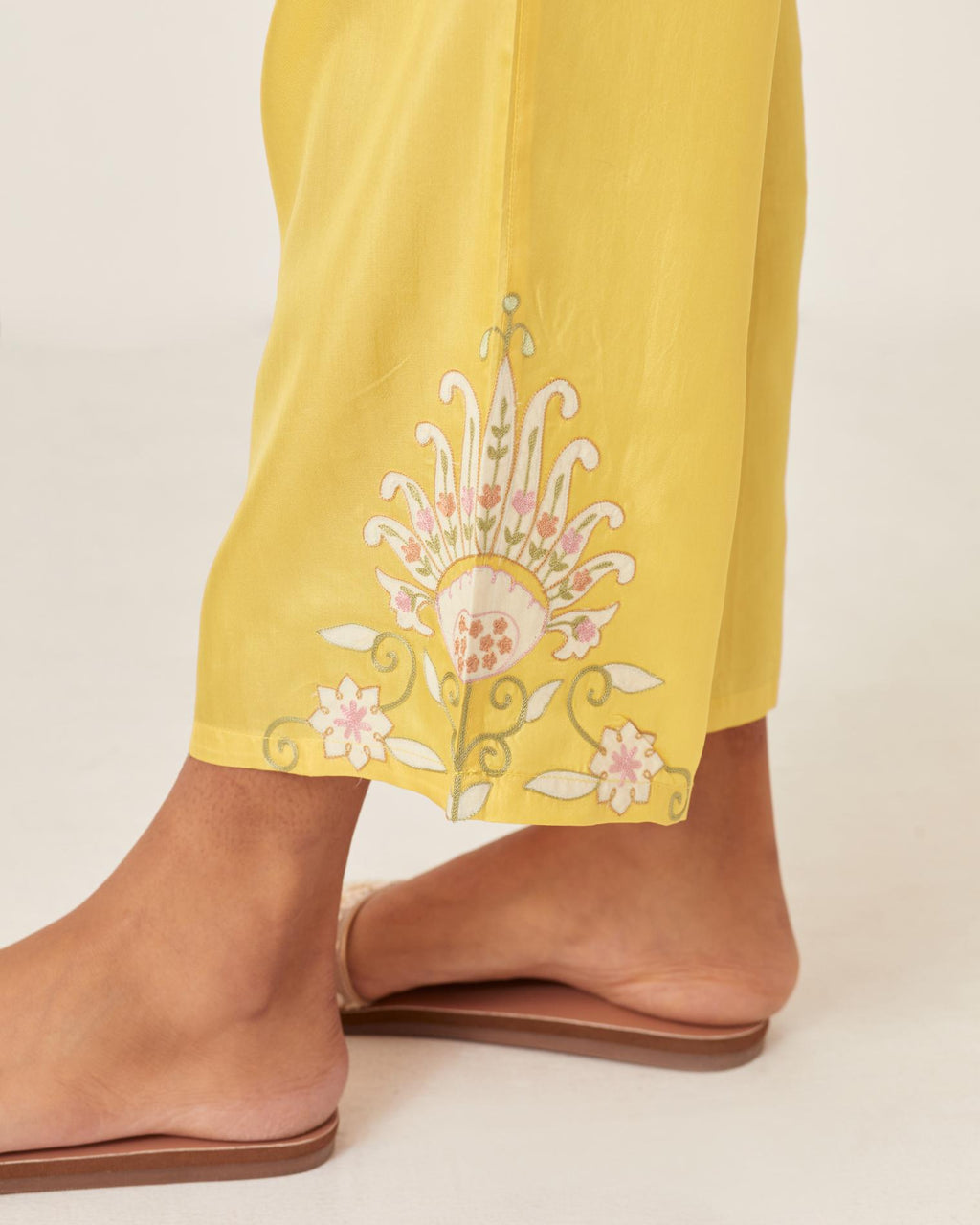 Yellow silk straight pants with multi colored appliqué at hem.