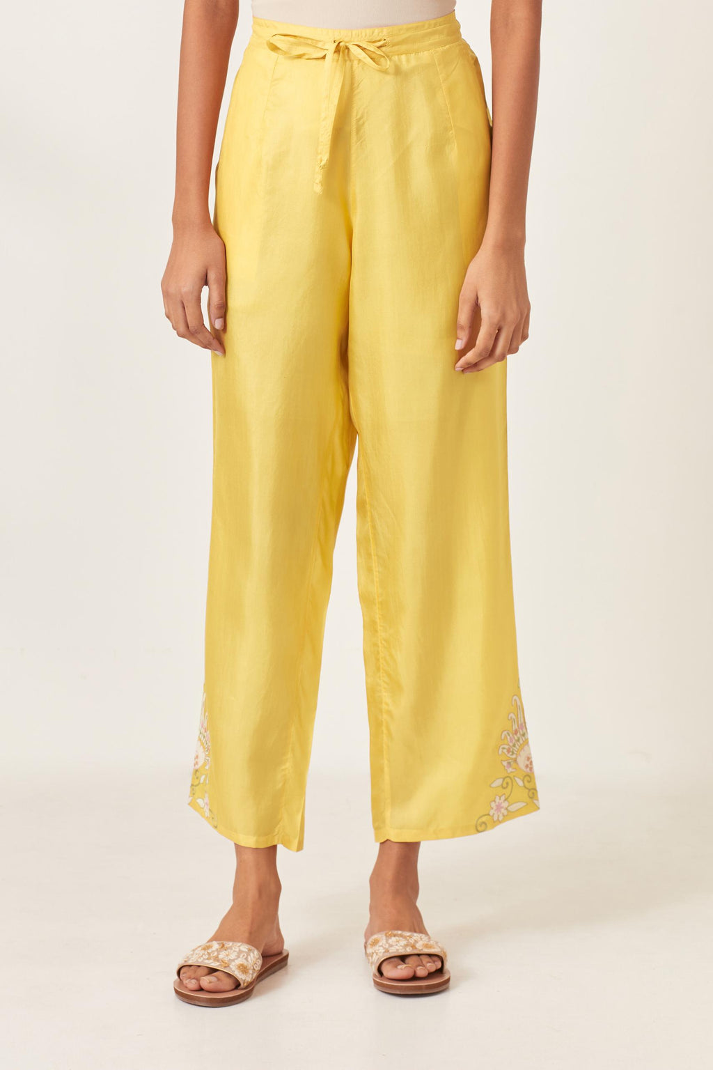 Yellow silk straight pants with multi colored appliqué at hem.