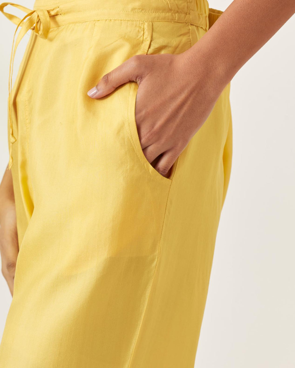 Yellow silk straight pants with multi colored appliqué at hem.