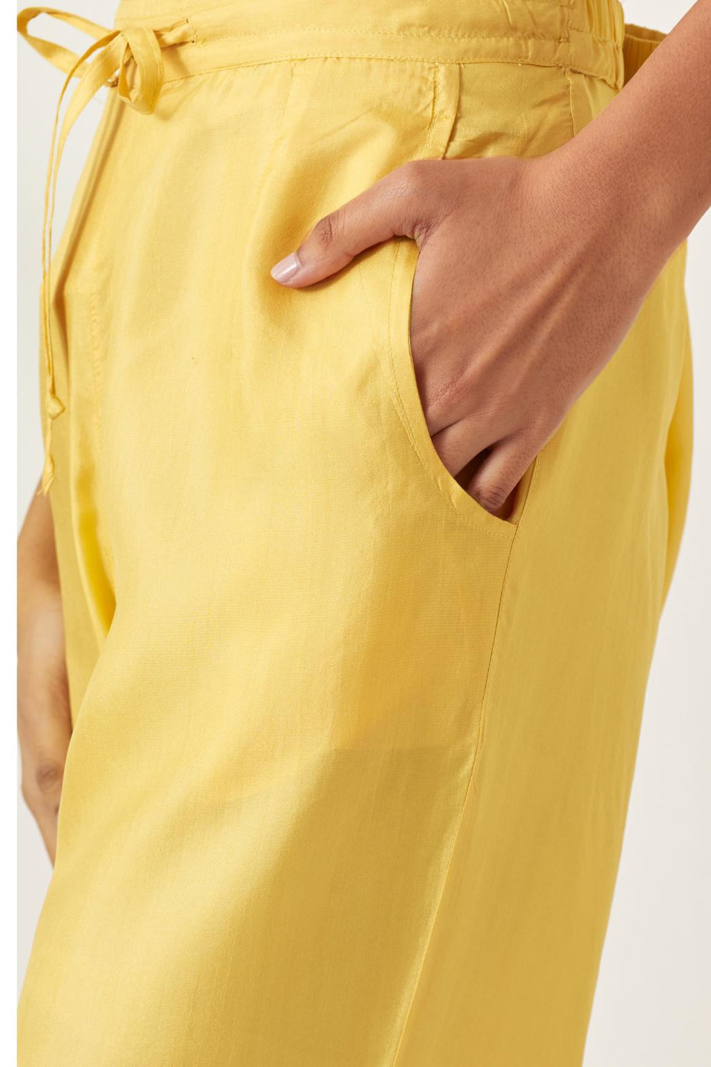 Yellow silk straight pants with multi colored appliqué at hem.