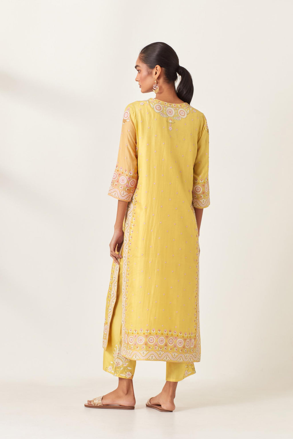 Yellow slim fit straight kurta set, decorated with bold appliqué borders all along the side seam, hem and sleeve cuffs.