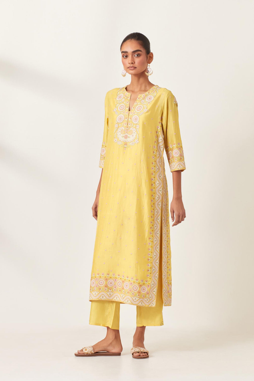 Yellow slim fit straight kurta set, decorated with bold appliqué borders all along the side seam, hem and sleeve cuffs.